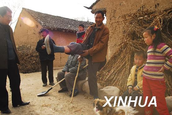 陕西省宝鸡市陇县东风镇南村一农民抬着腿说