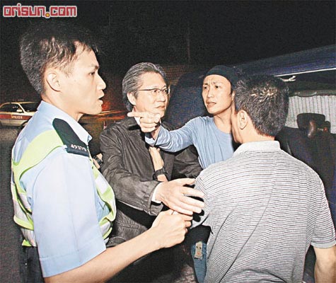 郑东汉(左二)跟警员讲述事件经过,郑中基则手指指十分劳气.